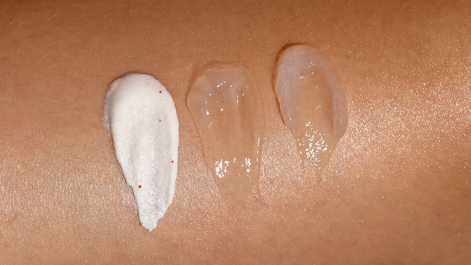 Skincare texture swatches on skin showing acne-safe cleanser, gel serum, and lightweight moisturizer for acne-prone skin